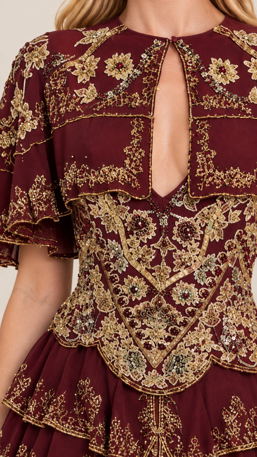 Close-up of gold embroidery and keyhole neckline on burgundy dress
