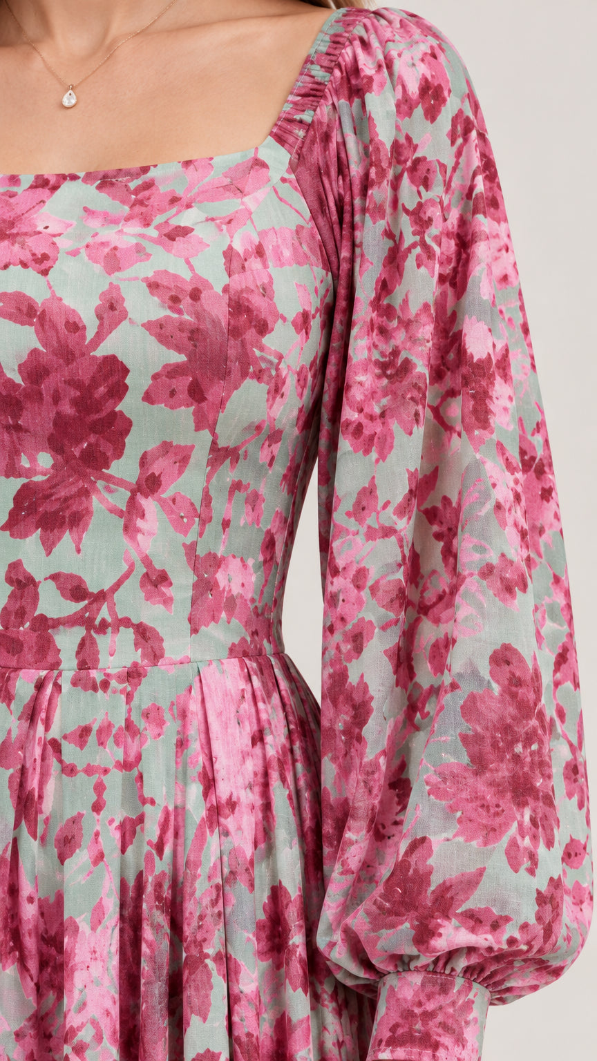 Close-up detail of square neckline and balloon sleeve on floral woven dress
