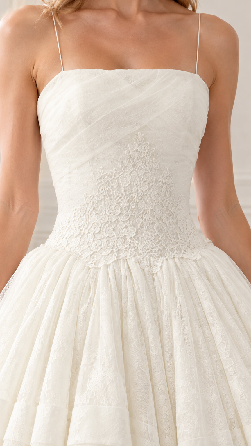 Close-up of straight neckline, pleated bodice, and floral lace appliqué