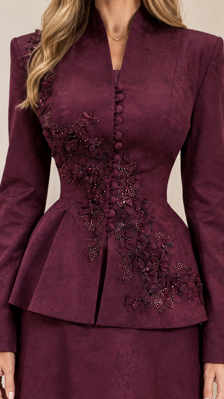 Close-up detail of embroidered floral applique and covered buttons on burgundy jacket