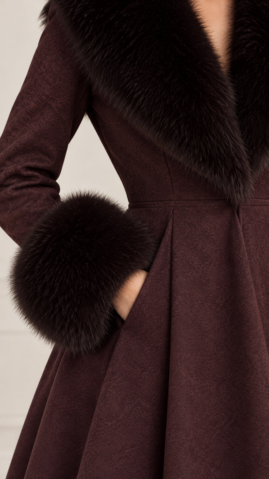 Close-up detail of textured fabric, faux fur cuff, and side pocket on Burgundy coat