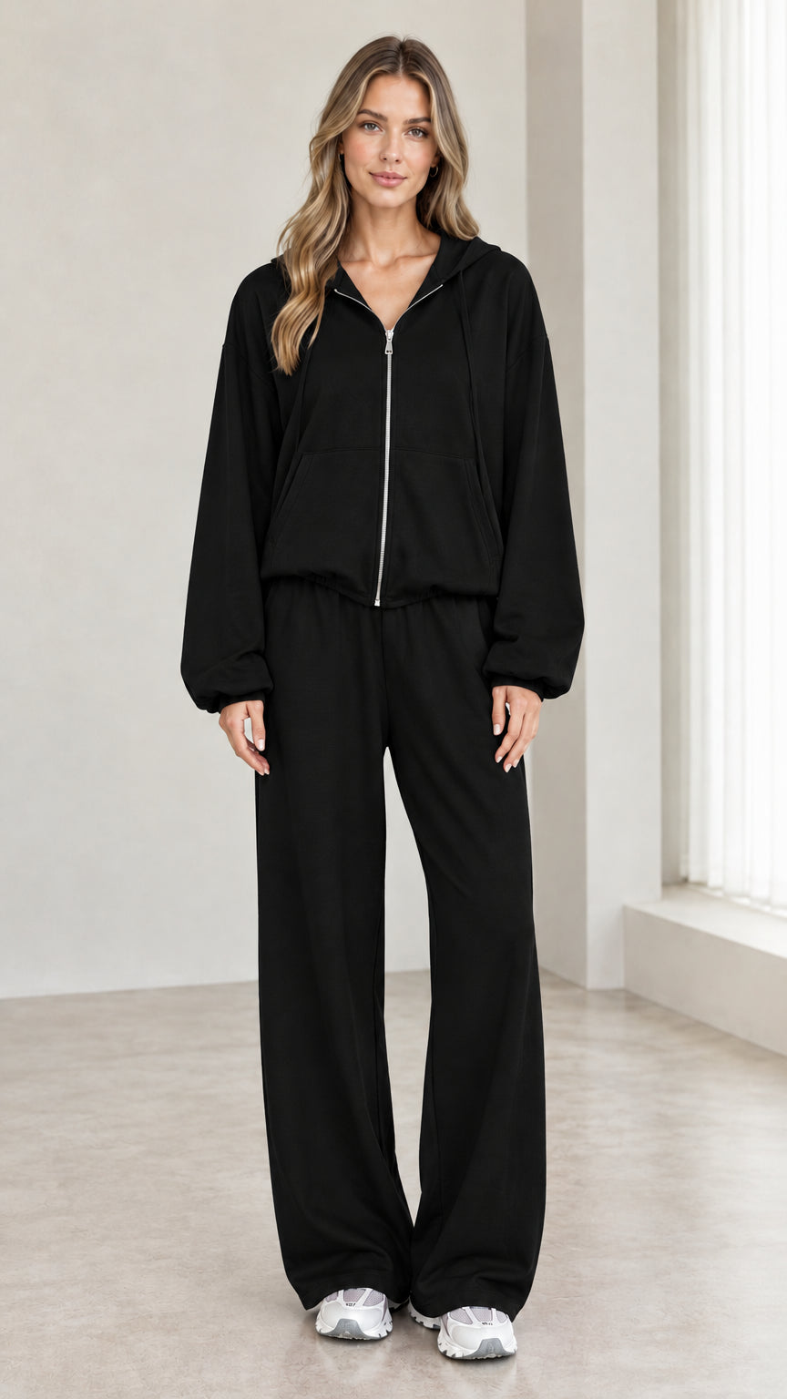 Woman wearing black 2-piece zip-up hoodie and wide-leg pants tracksuit set