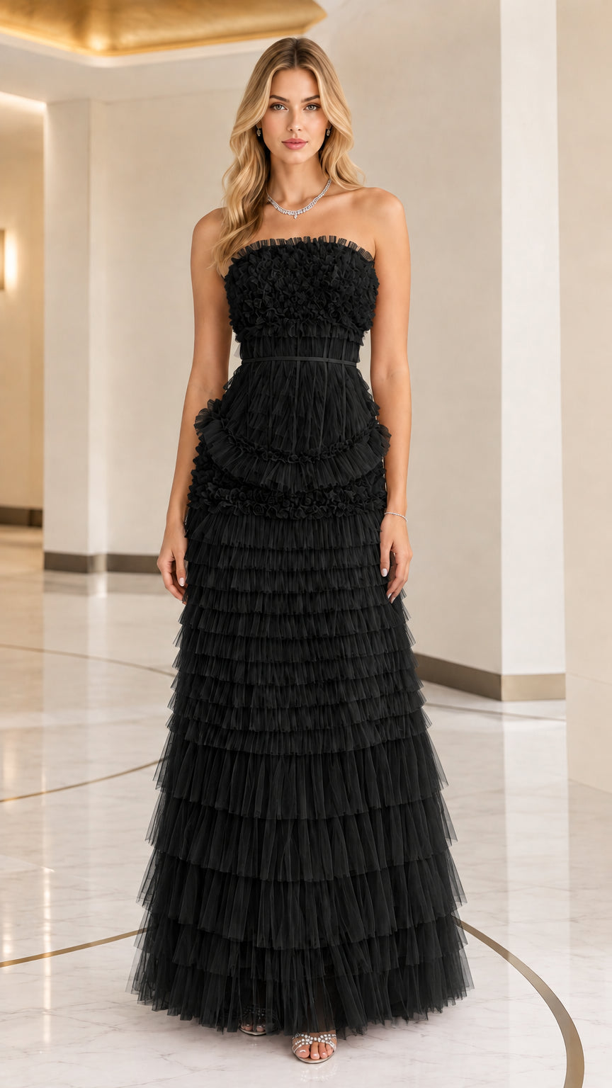 Front full view of woman wearing strapless black tiered ruffle tulle formal maxi dress