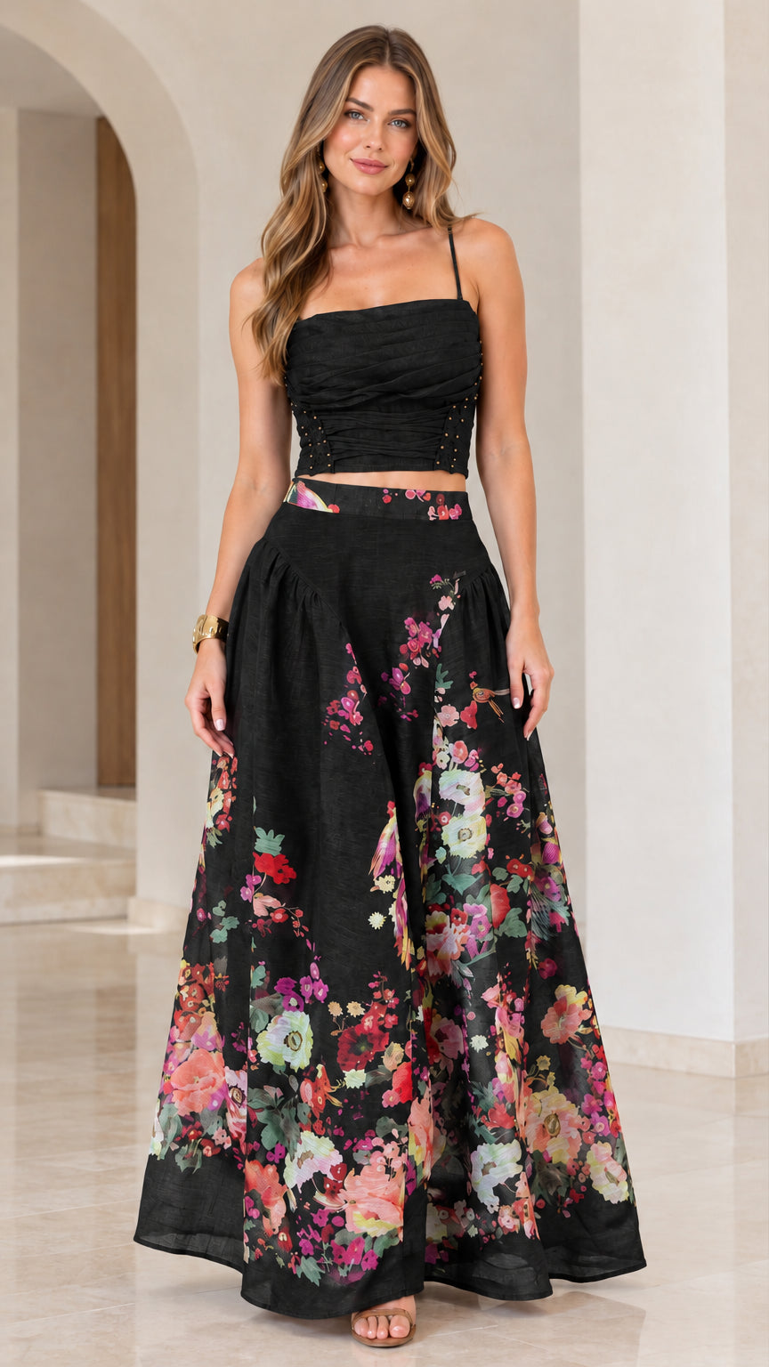 Full-length view of black floral ruched crop top and flowing maxi skirt set