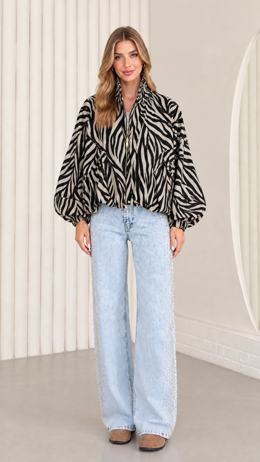 Model wearing classic black and cream zebra print balloon sleeve jacket with wide-leg jeans