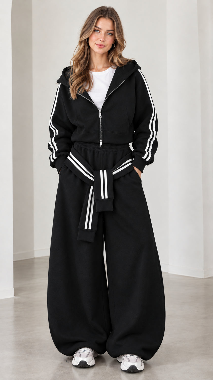 Model wearing black cropped hoodie and wide-leg track pants set