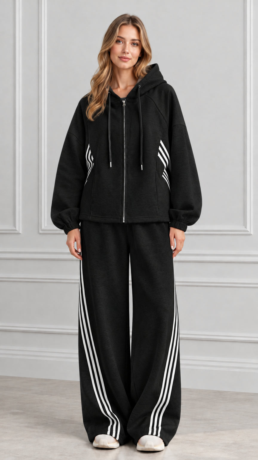 Front view of woman wearing Black zip-up hoodie and wide-leg pants set with white stripes