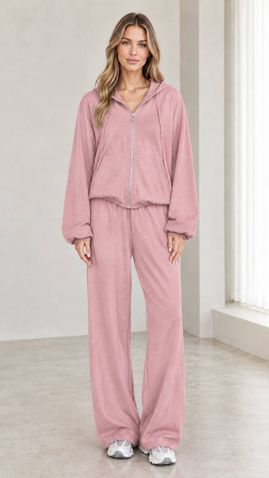 Woman wearing dusty pink 2-piece zip-up hoodie and wide-leg pants tracksuit set