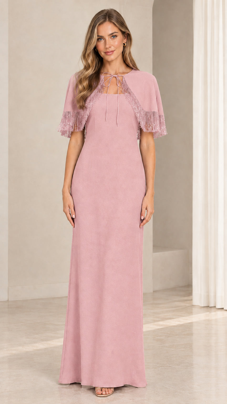 Model wearing dusty rose pink evening gown with fringe capelet overlay