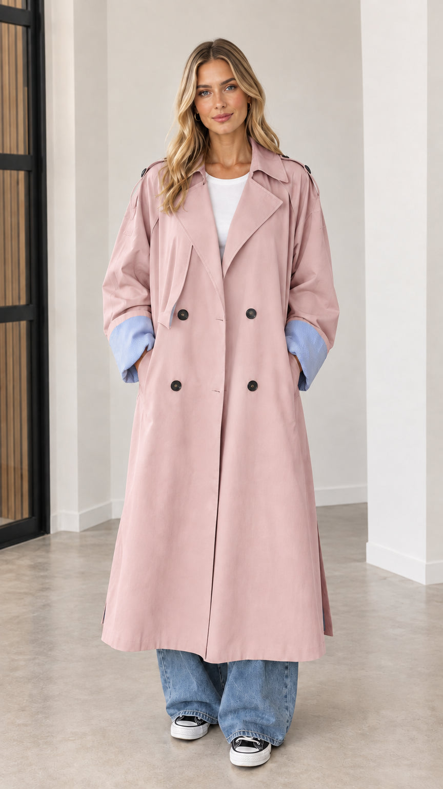 Front full view of dusty pink oversized maxi trench coat with blue contrast cuffs