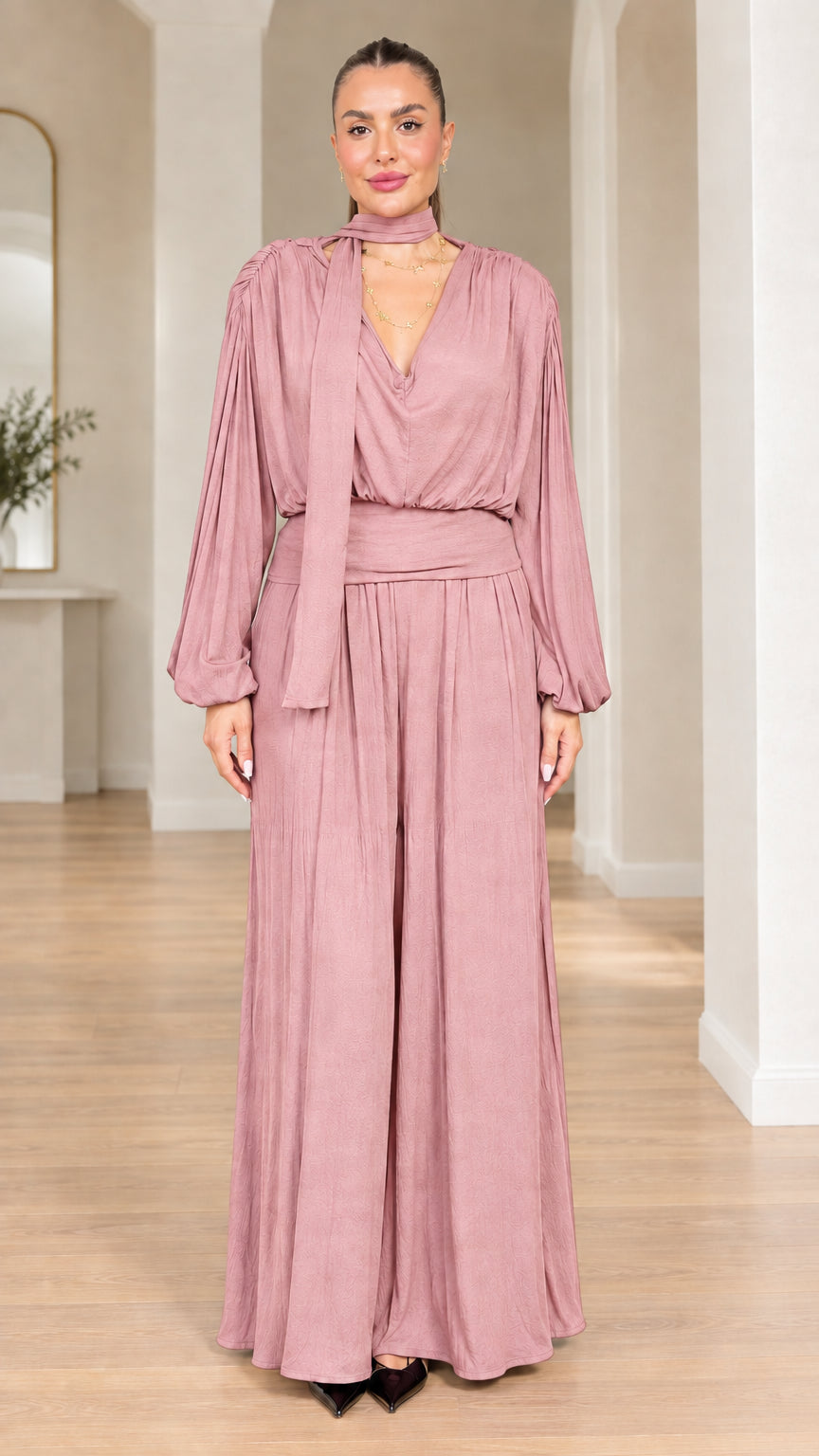 Model wearing dusty rose long-sleeve wide-leg evening jumpsuit