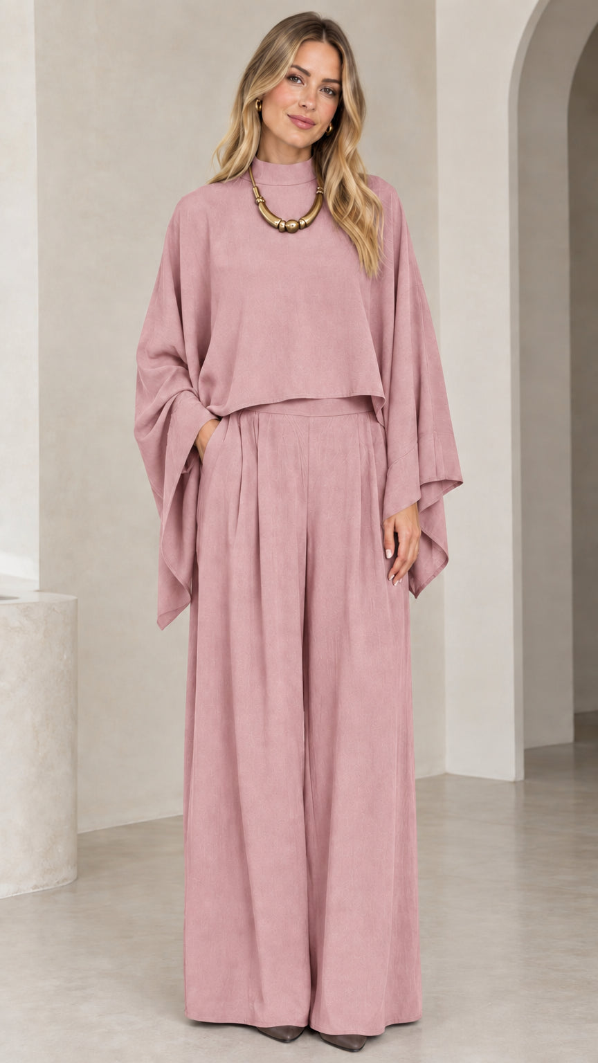 Full-length view of woman in dusty rose pink cape sleeve top and wide leg palazzo trousers