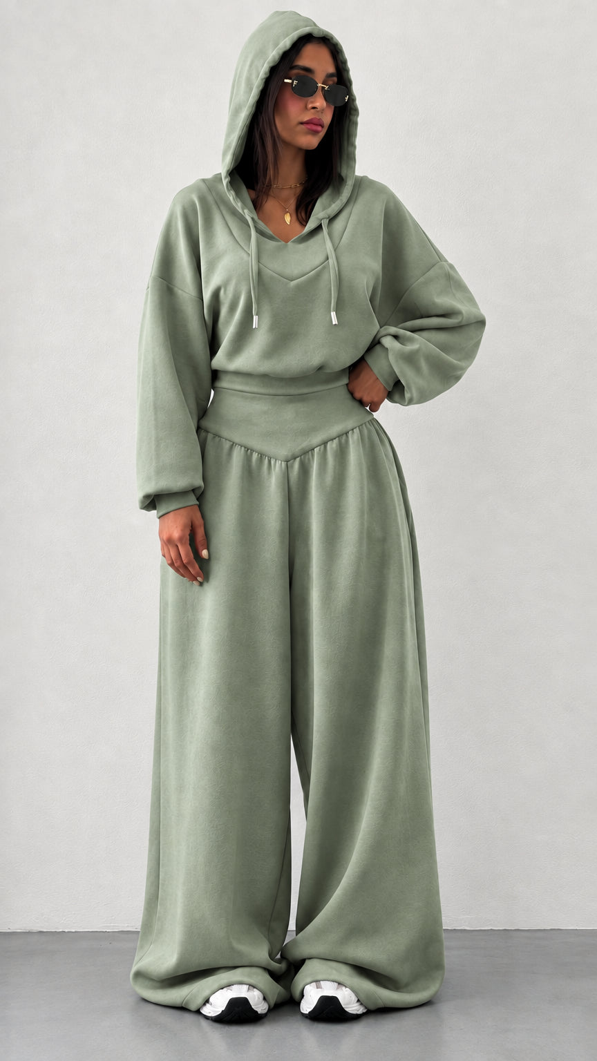 Woman wearing sage green 2-piece hooded sweatshirt and wide leg pants set