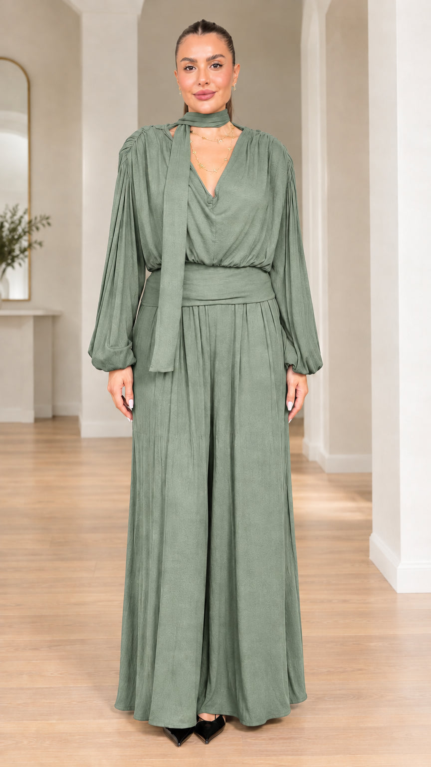 Model wearing sage green long-sleeve scarf neck wide-leg jumpsuit