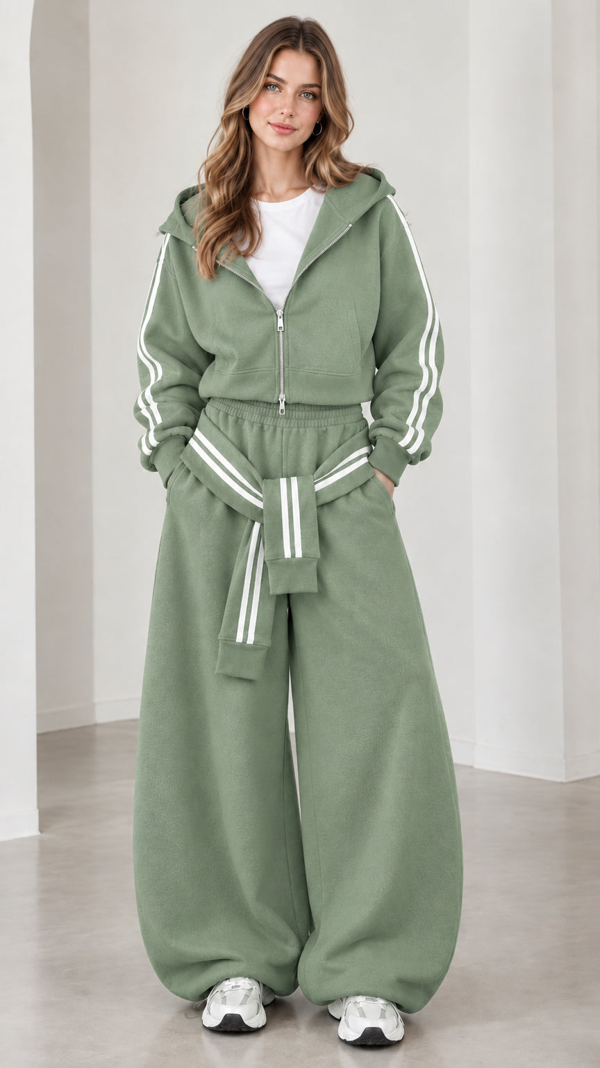Model wearing sage green cropped hoodie and baggy track pants set