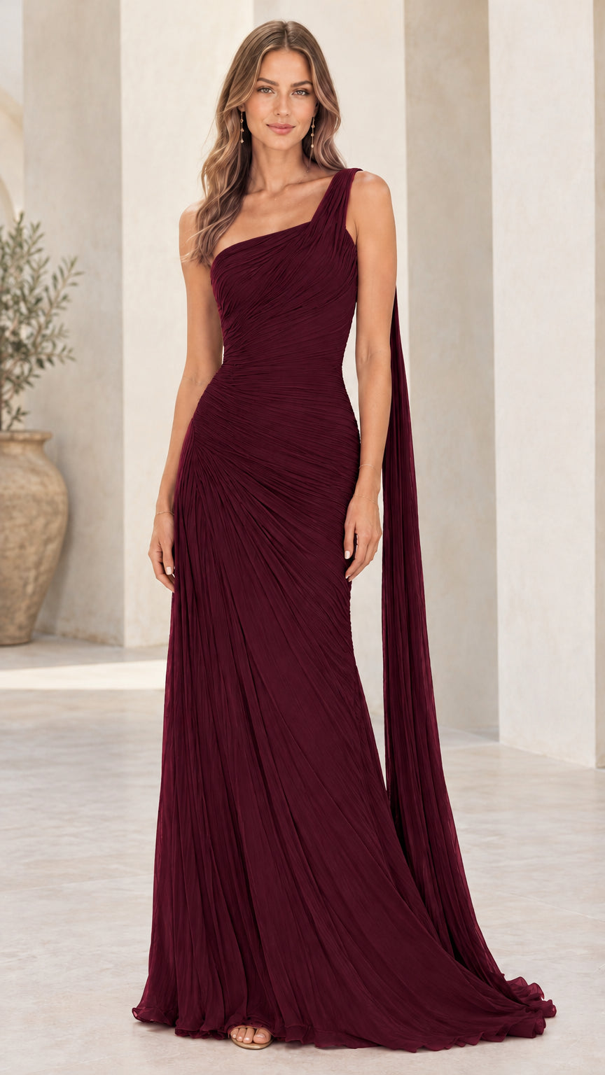 Front view of model wearing burgundy one-shoulder pleated evening gown with shoulder cape