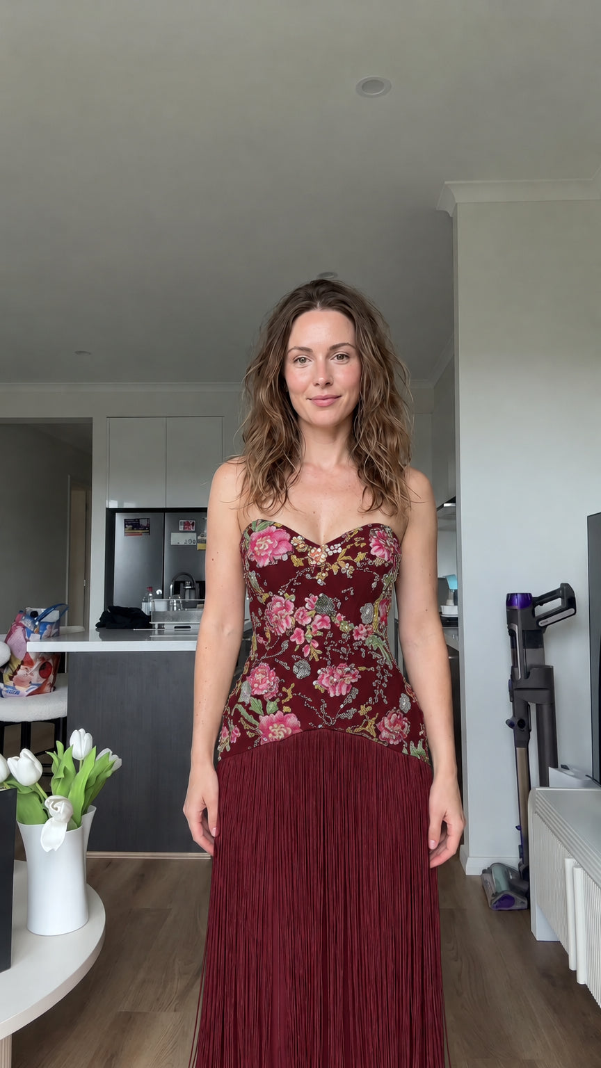 Woman modeling burgundy wine floral embroidered strapless fringe evening dress
