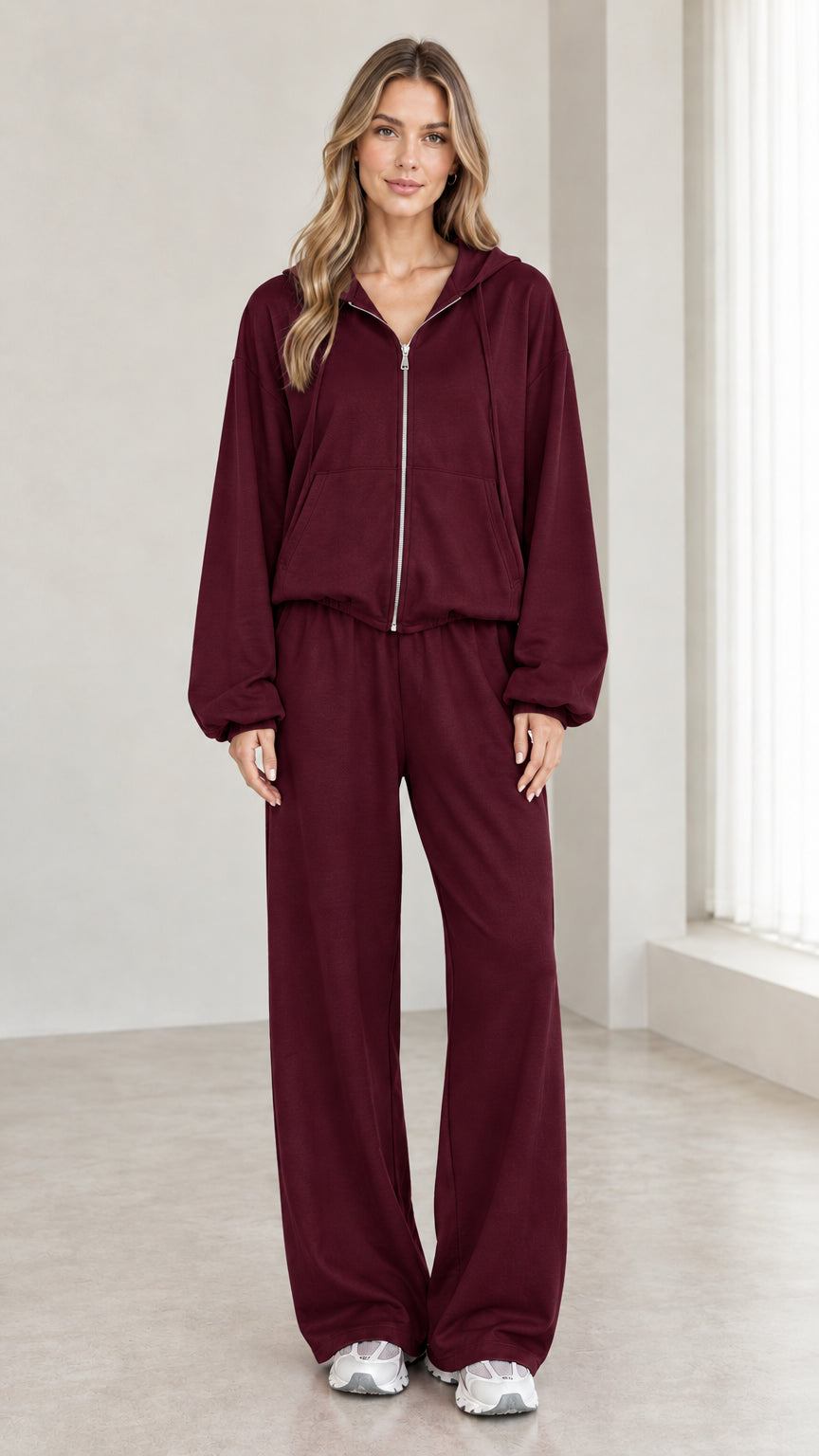 Woman wearing burgundy 2-piece zip-up hoodie and wide-leg pants tracksuit set