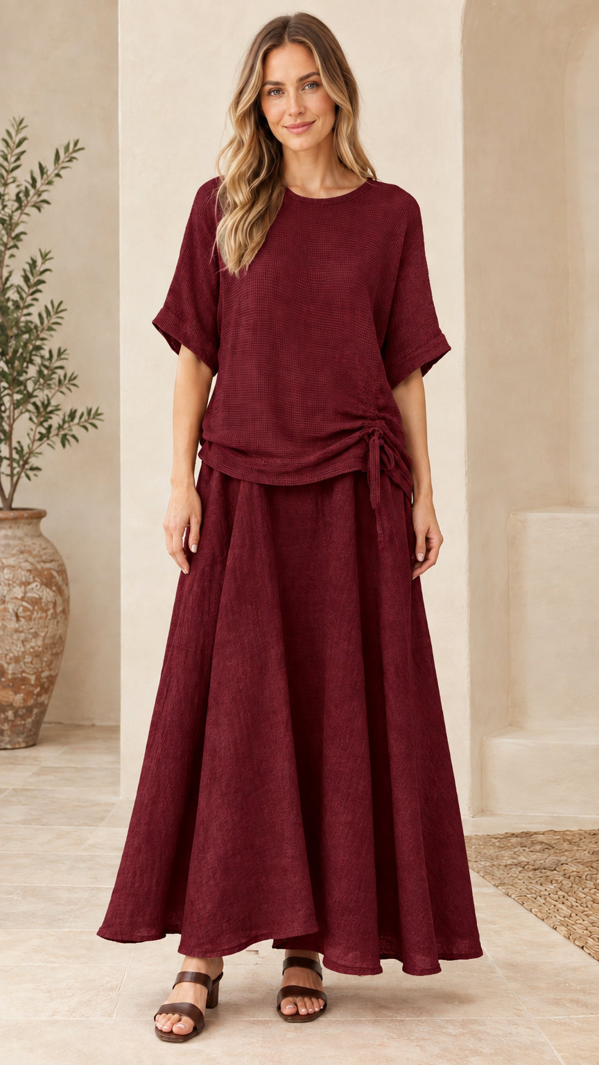 Front view of woman wearing burgundy wine textured two-piece top and maxi skirt set