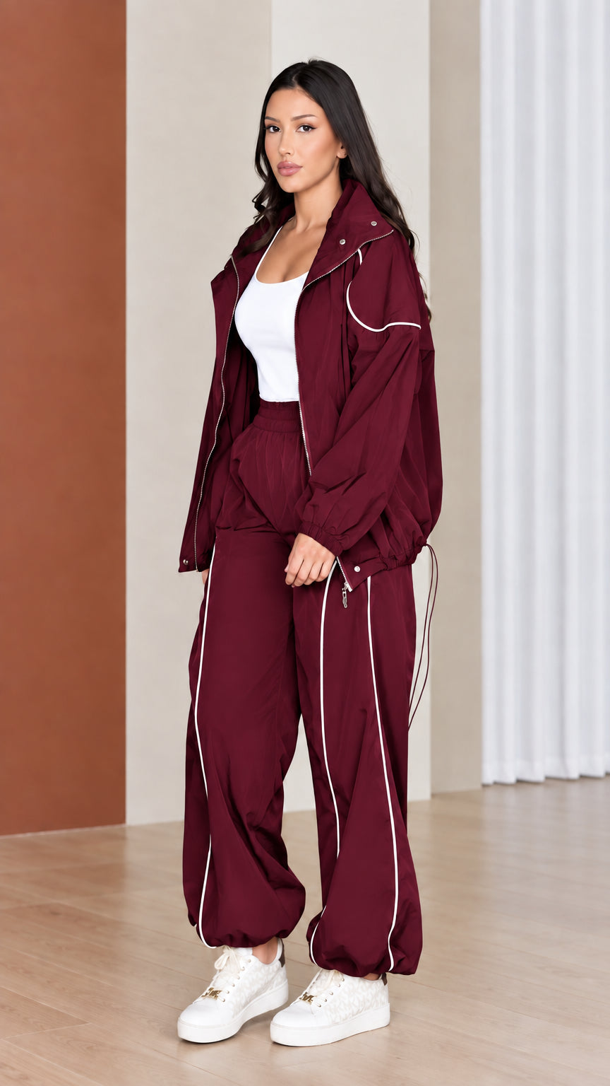 Full-length view of woman wearing rich burgundy red windbreaker tracksuit set
