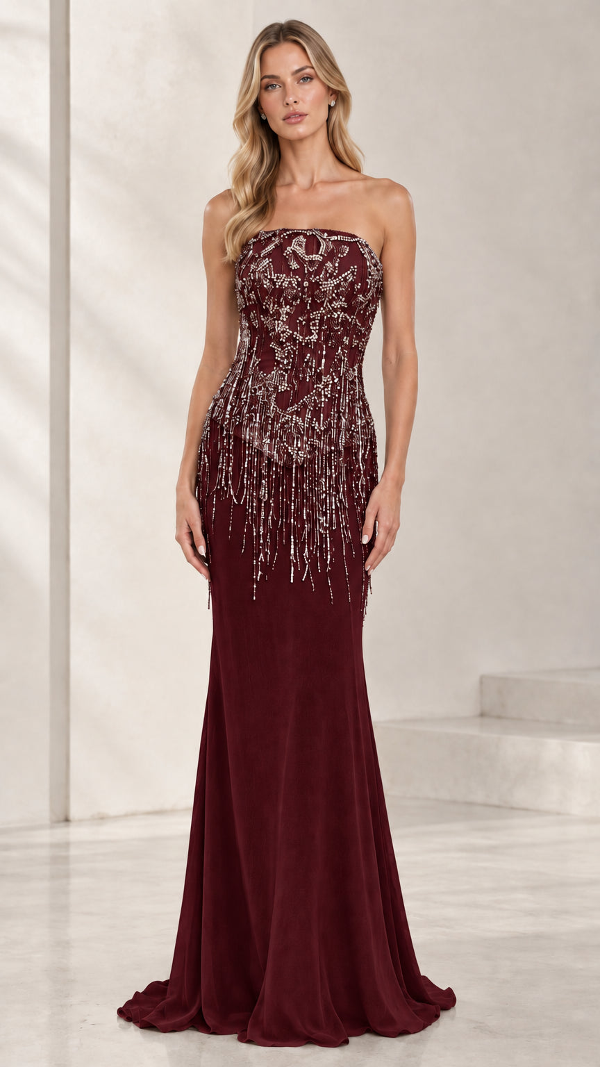 Model wearing deep burgundy strapless beaded fringe evening gown