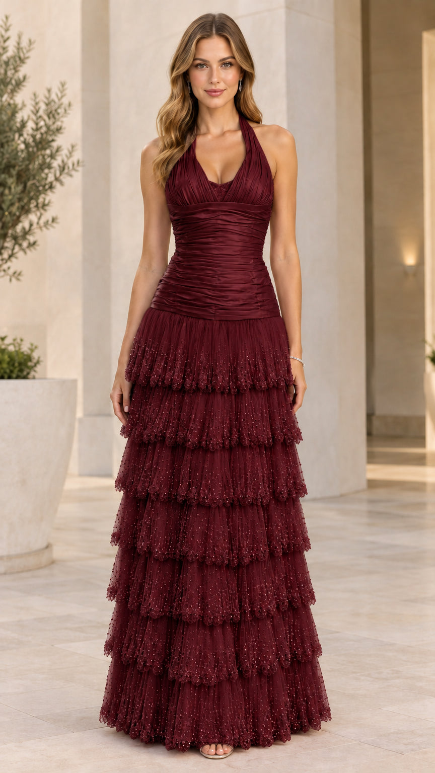 Model wearing burgundy halter ruched bodice tiered tulle formal dress
