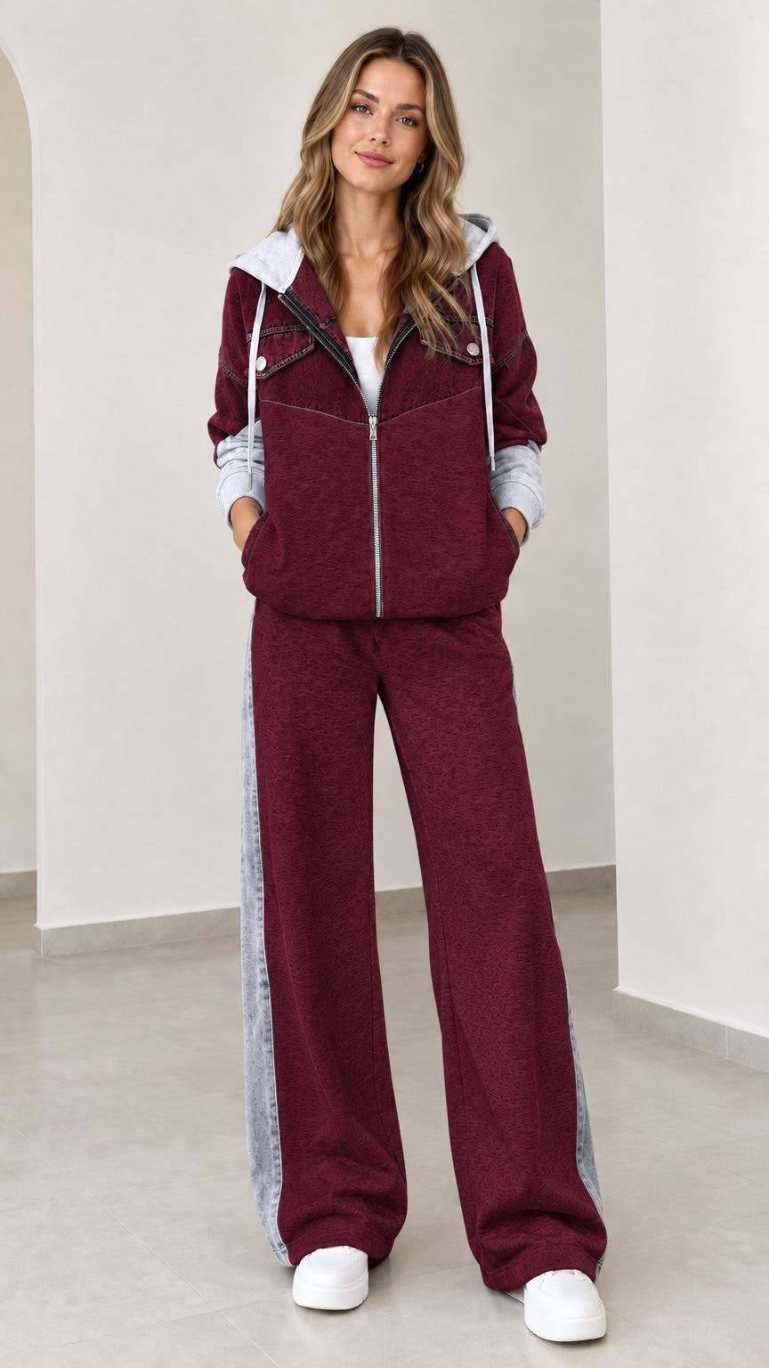 Model wearing burgundy two-piece zip-up hoodie and wide-leg pants set with contrast panels