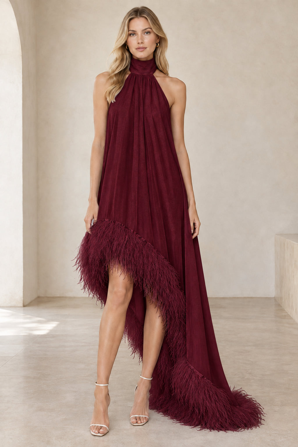 Model wearing burgundy wine halter high-low evening dress with feather trim