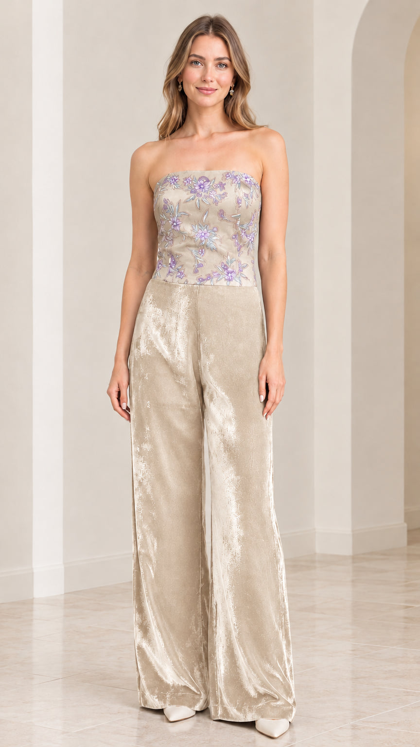 Front view of woman wearing strapless champagne beige floral velvet wide leg jumpsuit
